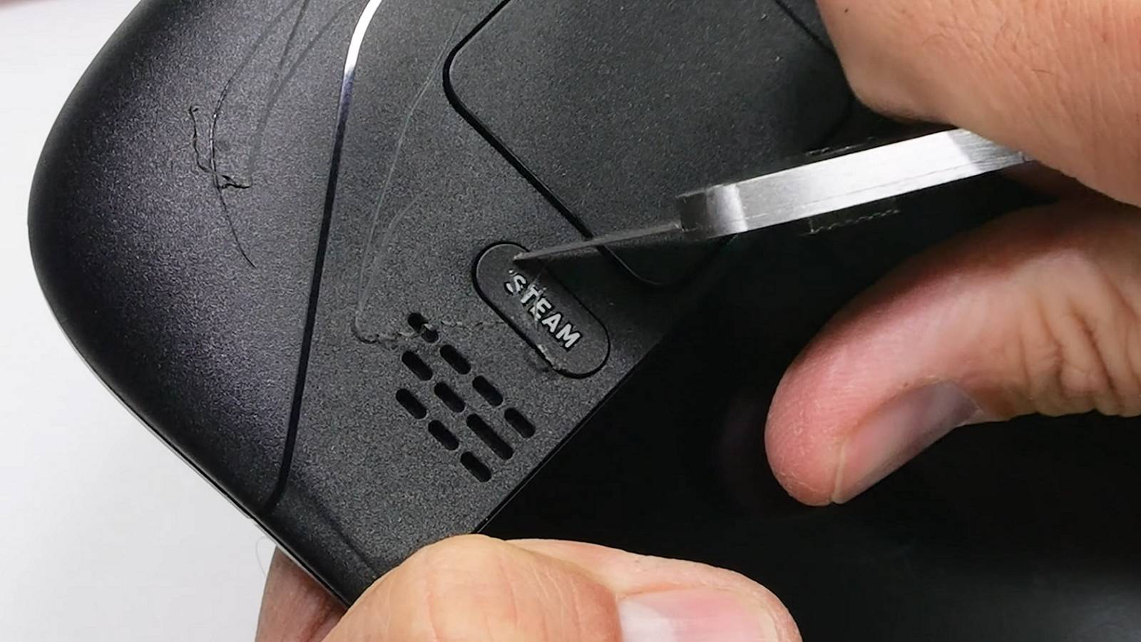 Close up image of someone scratching the buttons of a Steam Deck.
