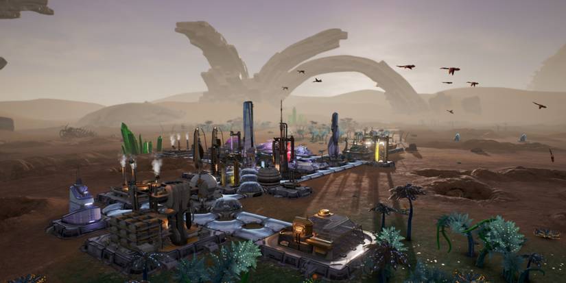 A small amount of buildings on a planet with an arch in the background of Aven Colony