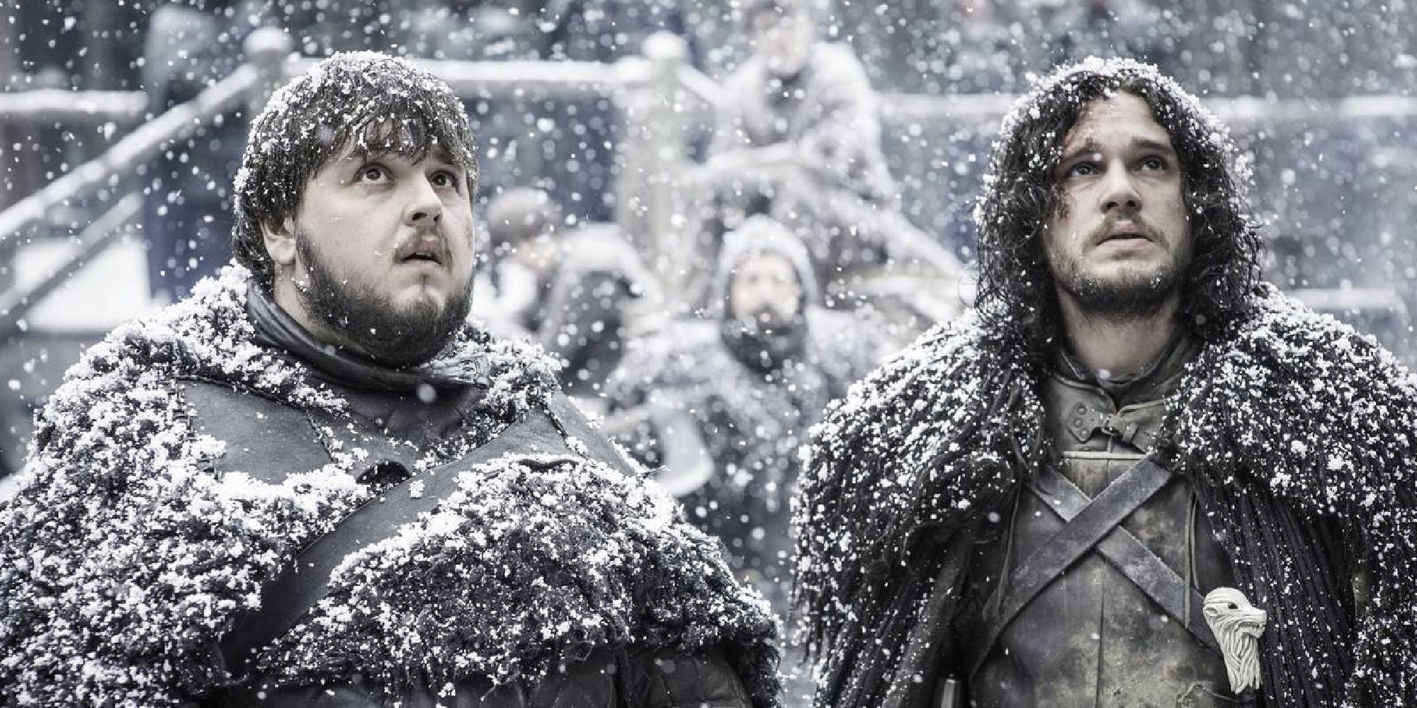 Jon Snow standing in the Castle Black courtyard with Samwell Tarly as it snows in Game of Thrones.