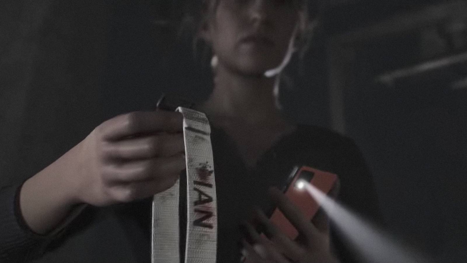 Laura holding a bloodied collar in the quarry