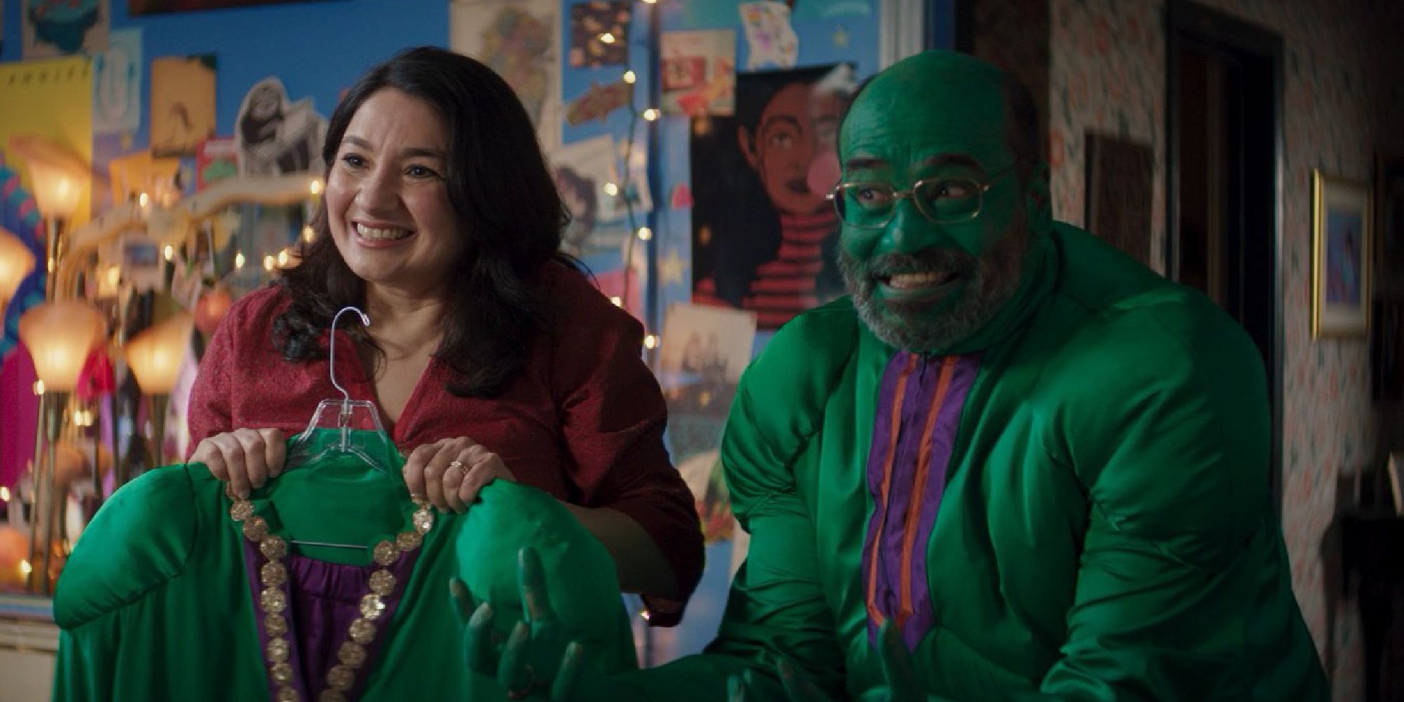 Kamala Khan's mom holding up a Hulk outfit next to Kamala's father dressed as the Hulk