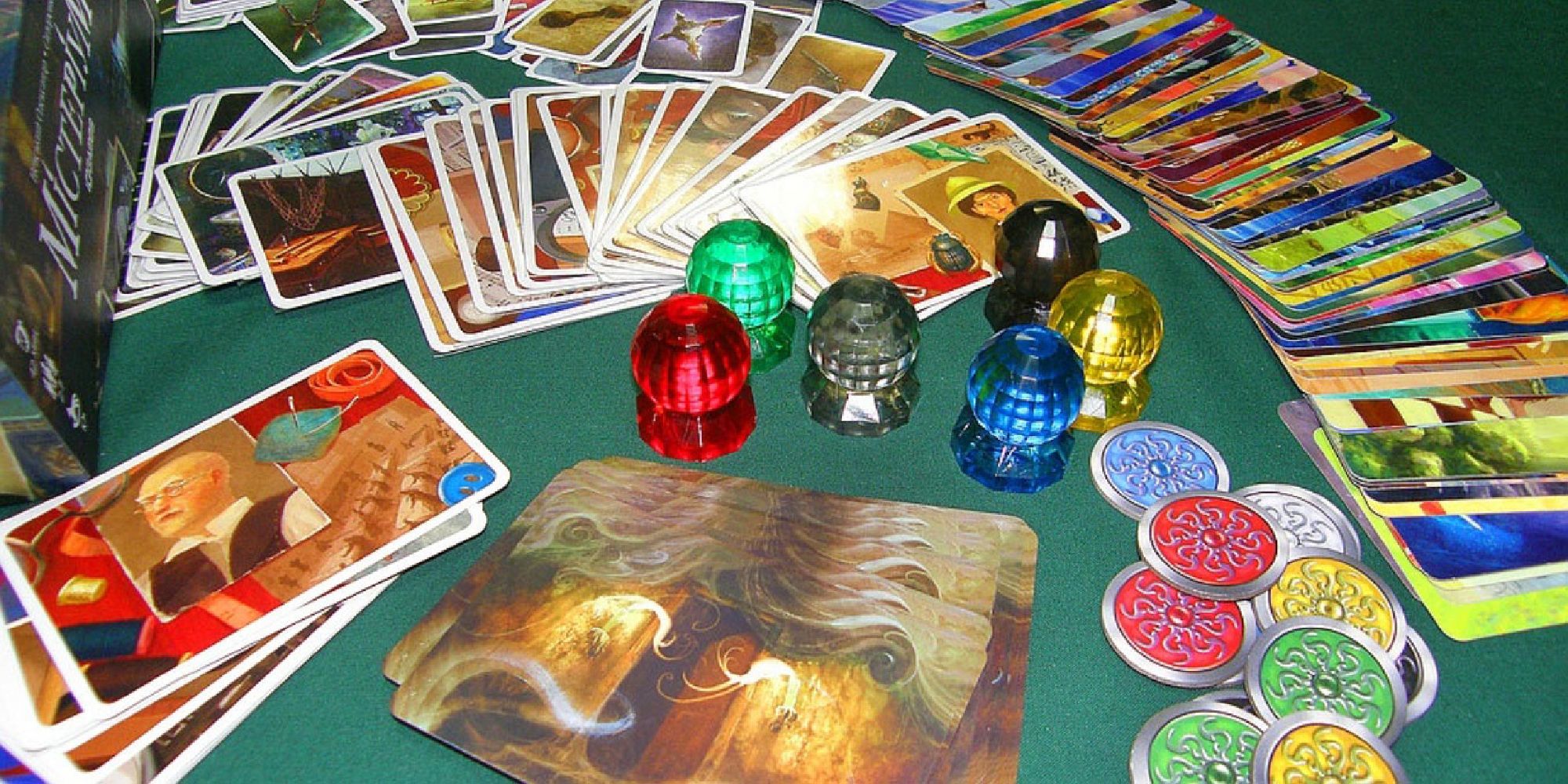Cards, game pieces, and tokens for the game Mysterium laid out on a table