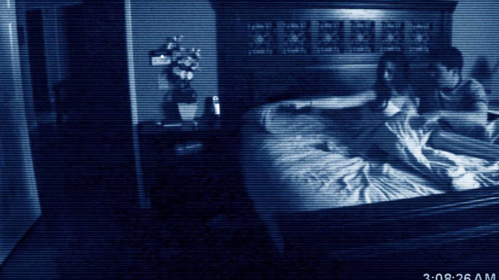 Katie and Micah scared in bed in Paranormal Activity (2007)
