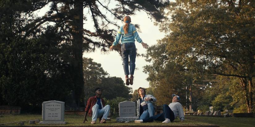 Max levitating above Billy's grave as Lucas, Steve, and Dustin watch from below in season 4