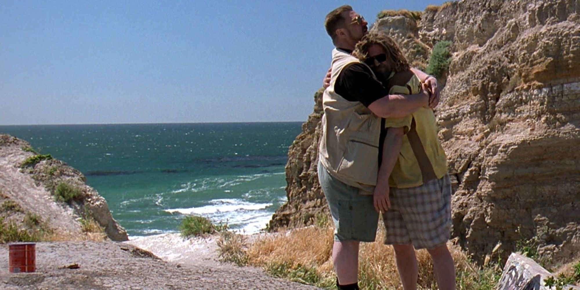 Walter hugs the Dude at the beach in The Big Lebowski