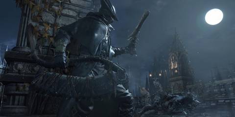 The Hunter looking toward buildings during the night in Bloodborne
