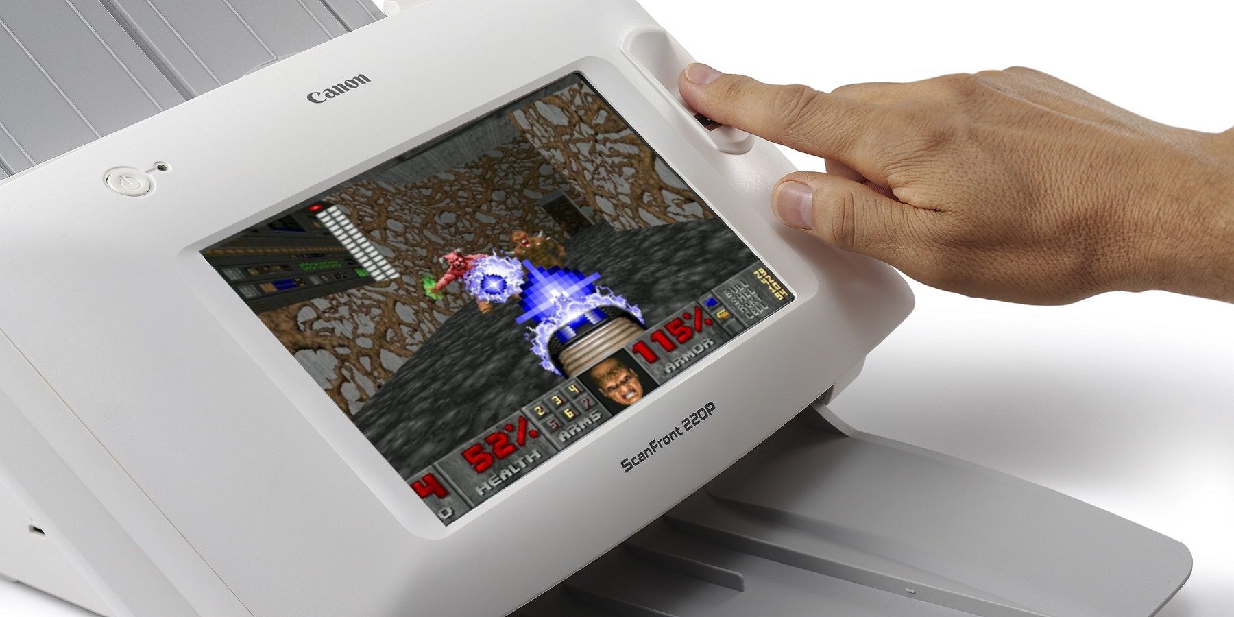 Image of a hand activating a Canon scanner that has Doom playing on the screen.