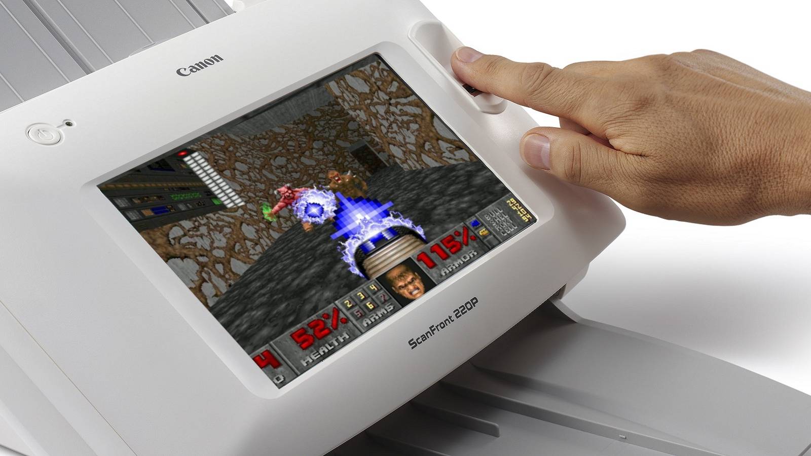Image of a hand activating a Canon scanner that has Doom playing on the screen.