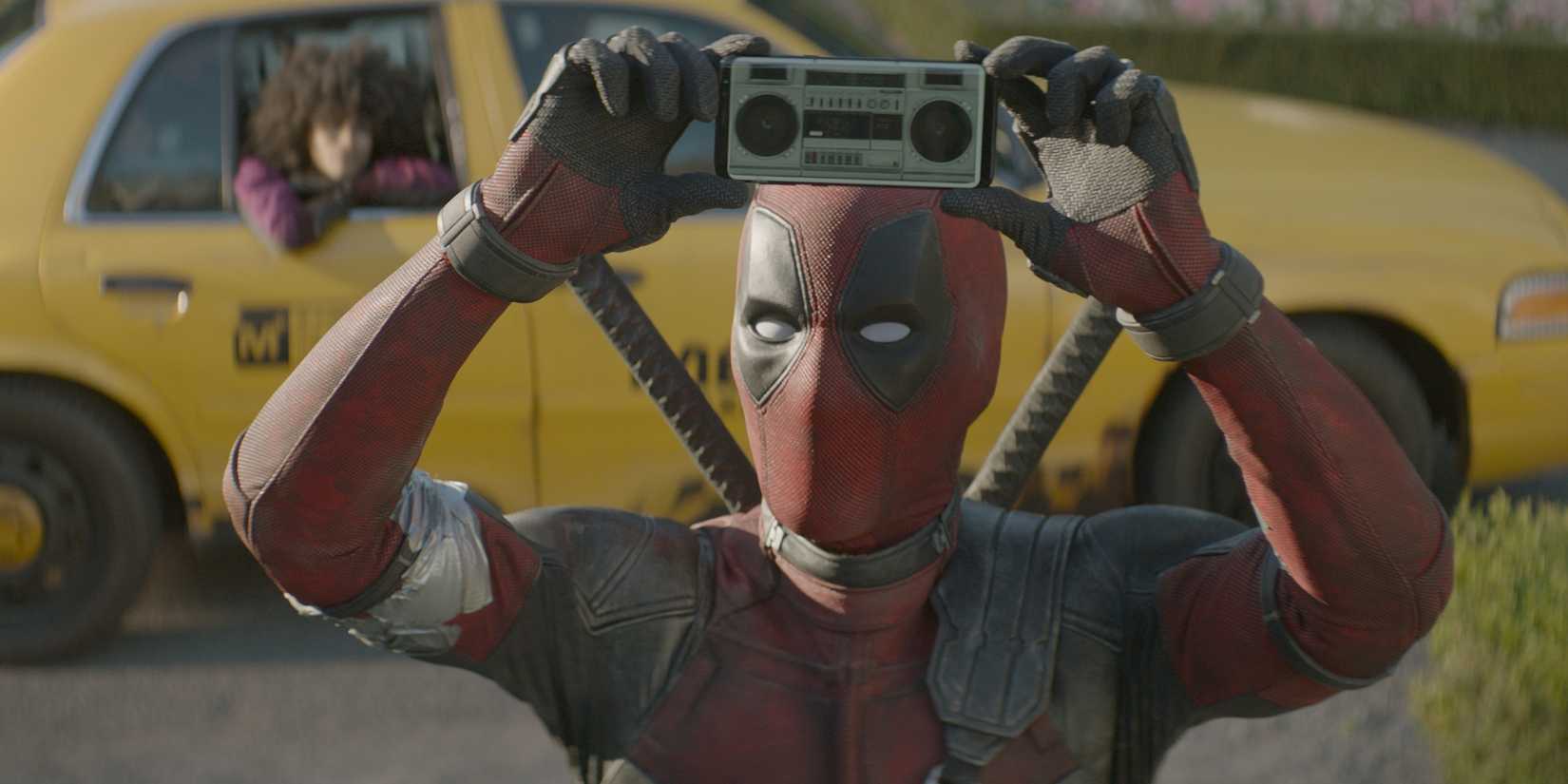 Deadpool playing music on his phone in Deadpool 2