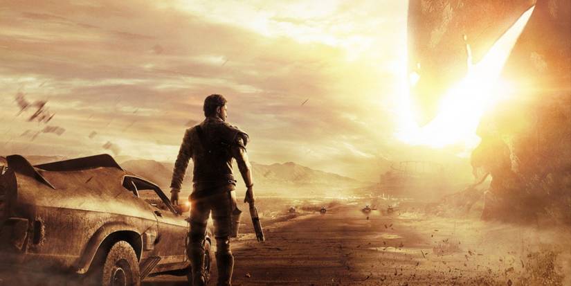 Mad Max stands alongside his car on a desert road