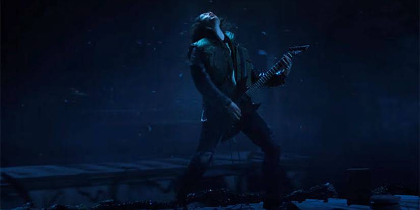 Eddie playing guitar on his trailer roof in the Upside-Down