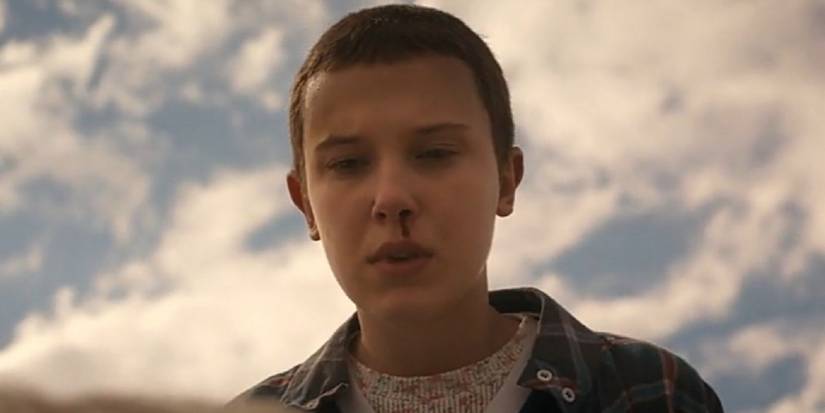 Eleven with a bloody nose looking down at Brenner in Episode 8