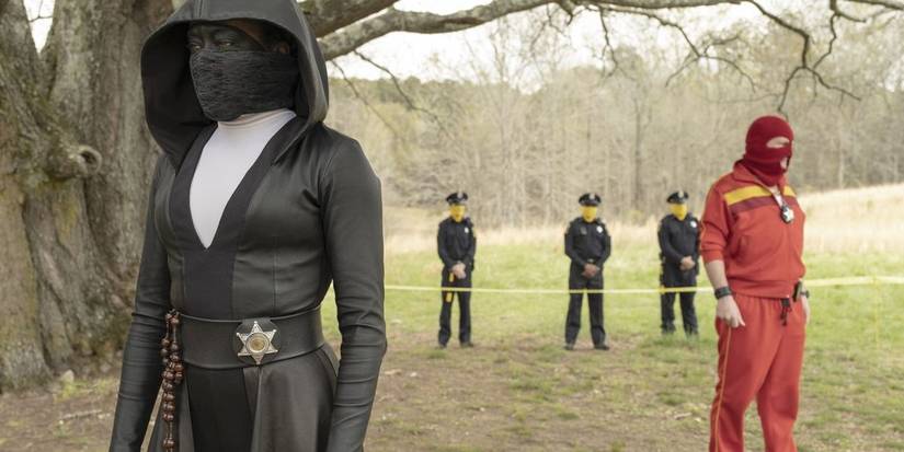 Watchmen TV series masked characters standing by taped police area in woods