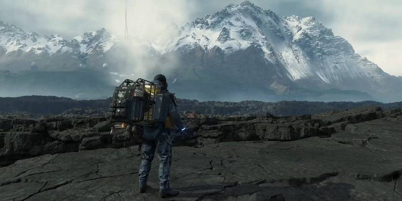Image from Death Stranding showing Sam looking at a mountain in the distance.