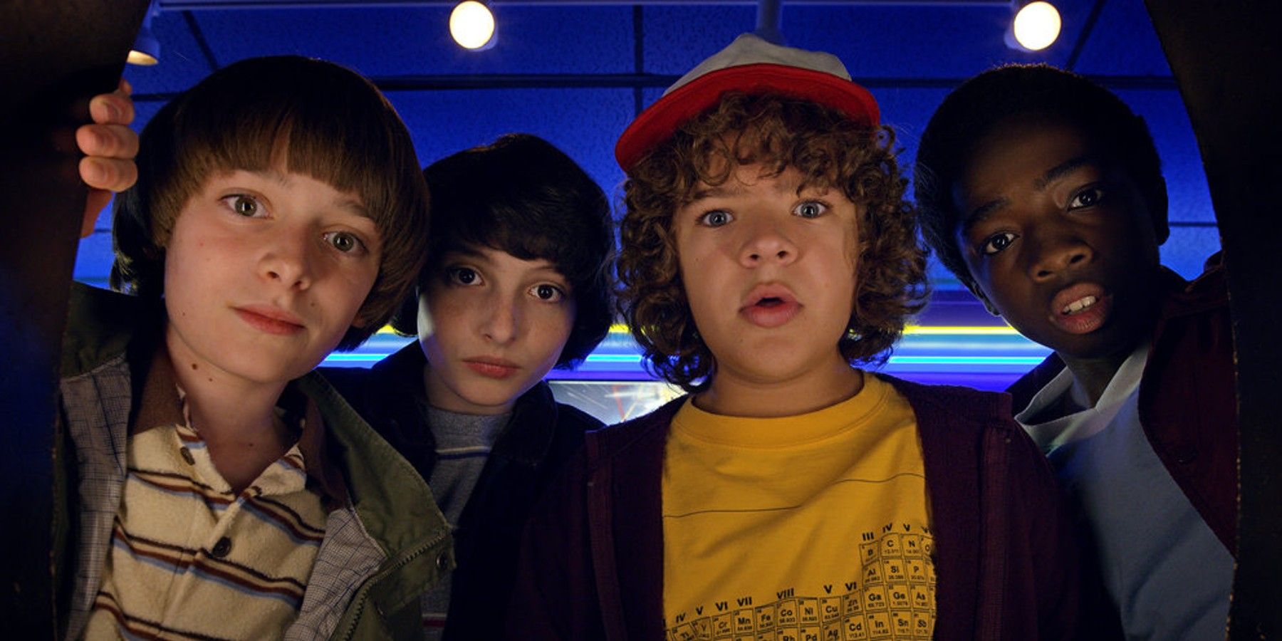 Will Byers, Mike Wheeler, Dustin Henderson, and Lucas Sinclair look at Dig Dug score in Stranger Things season 2