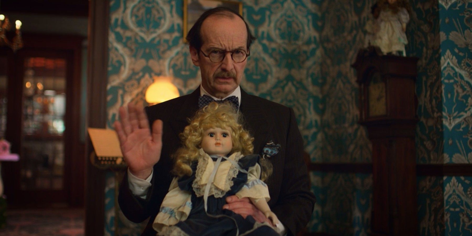 Van Wirt (Denis O'Hare) holds doll in American Horror Stories