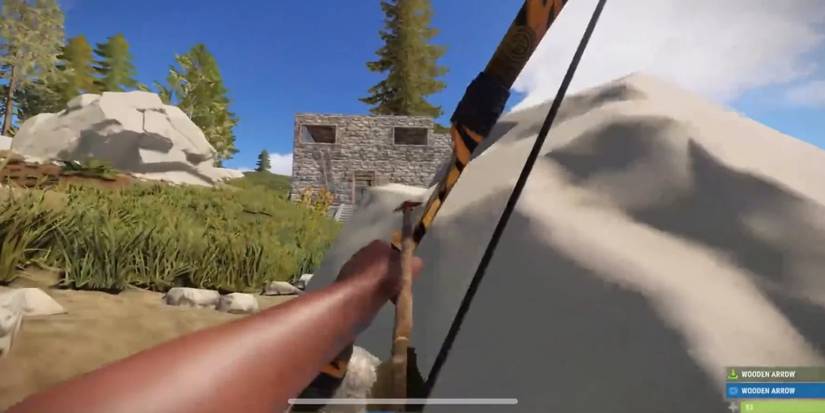 A player aiming at a stone building up a hill with a bow in Rust