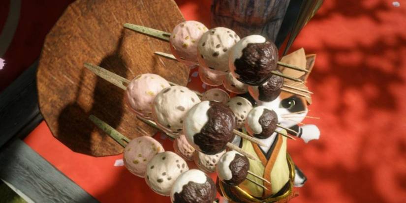 Palico catching a selection of Bunny Dango on a wooden tray in Monster Hunter Rise