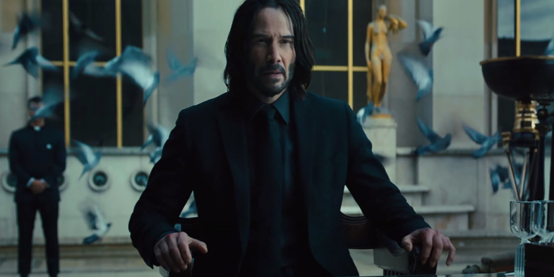 Keanu-sits-at-table-in-John-Wick-Chapter-4