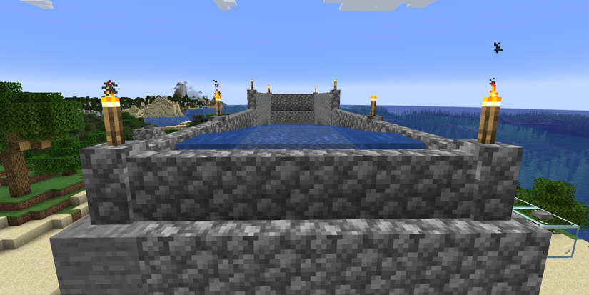 Minecraft torchers on cobblestone walls surrounding water
