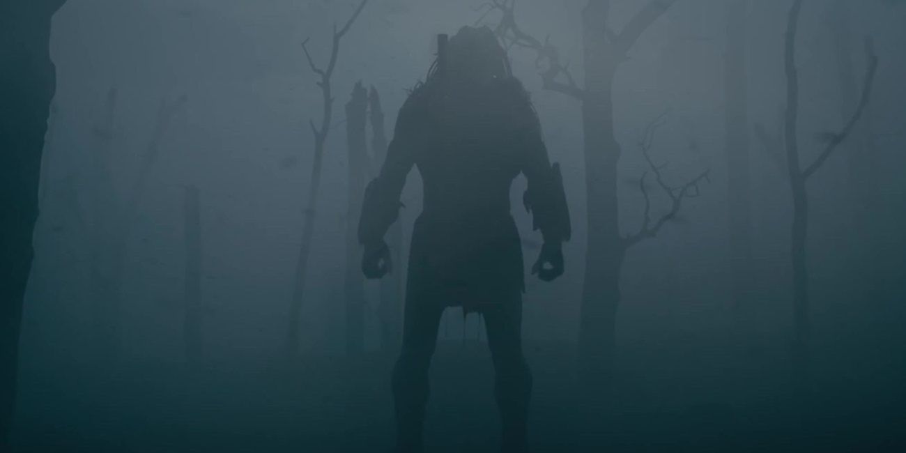 The Predator stands in a misty jungle in Prey