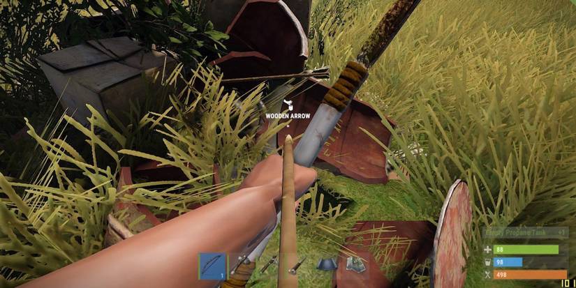 A player aiming a bow at a Wooden Arrow on the ground un Rust