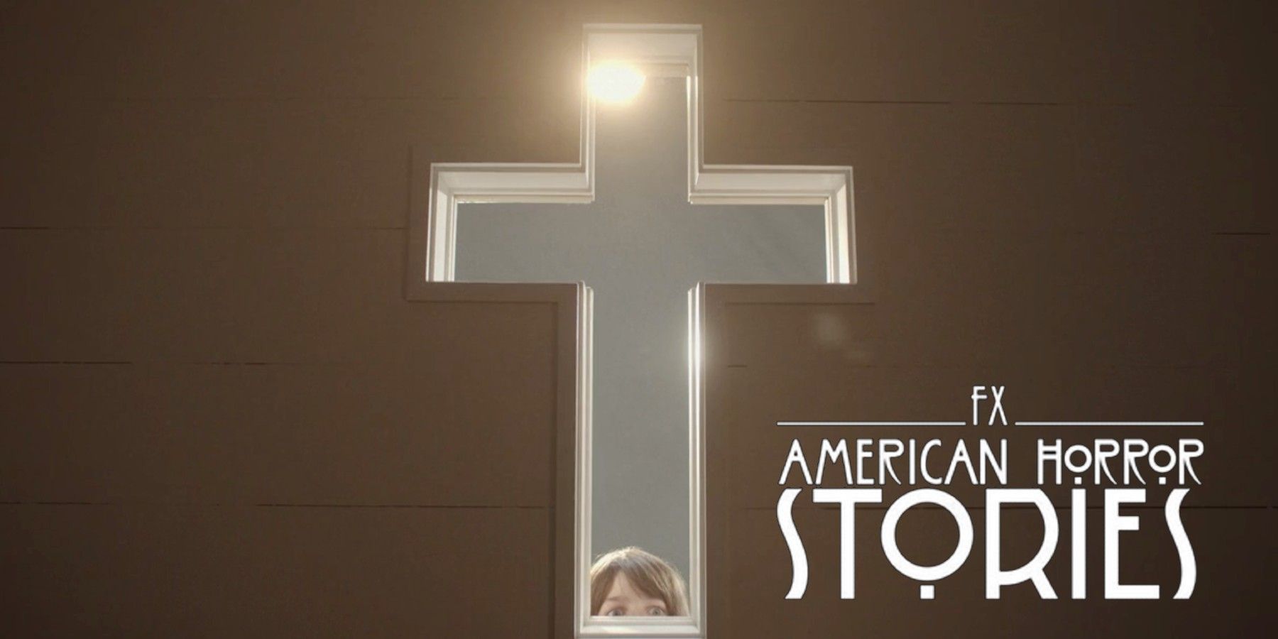 Edward (Ian Sharkey) peers through cross in American Horror Stories 