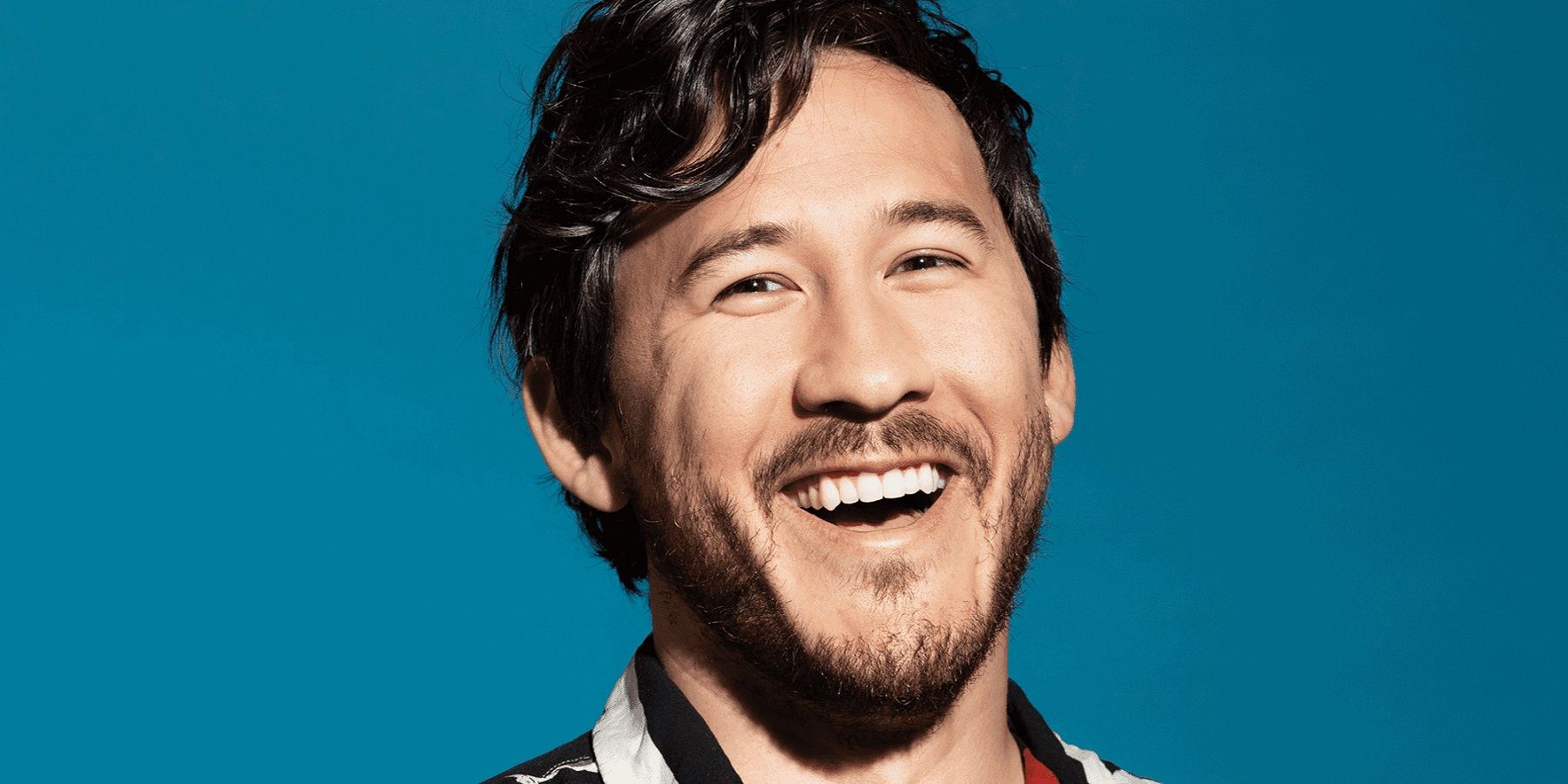 Close-up photo of YouTube star Markiplier on a teal background.