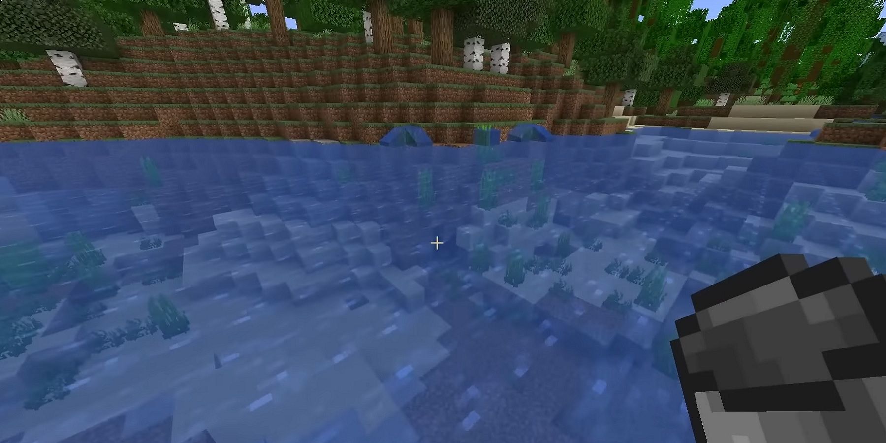 A screenshot from Minecraft showing a bucket about to go into a river.