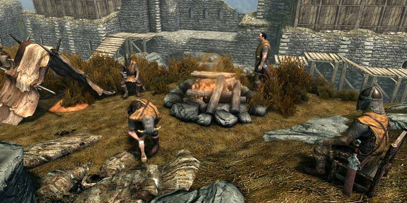 Image from Skyrim showing guards sat by a campfire in Whiterun.