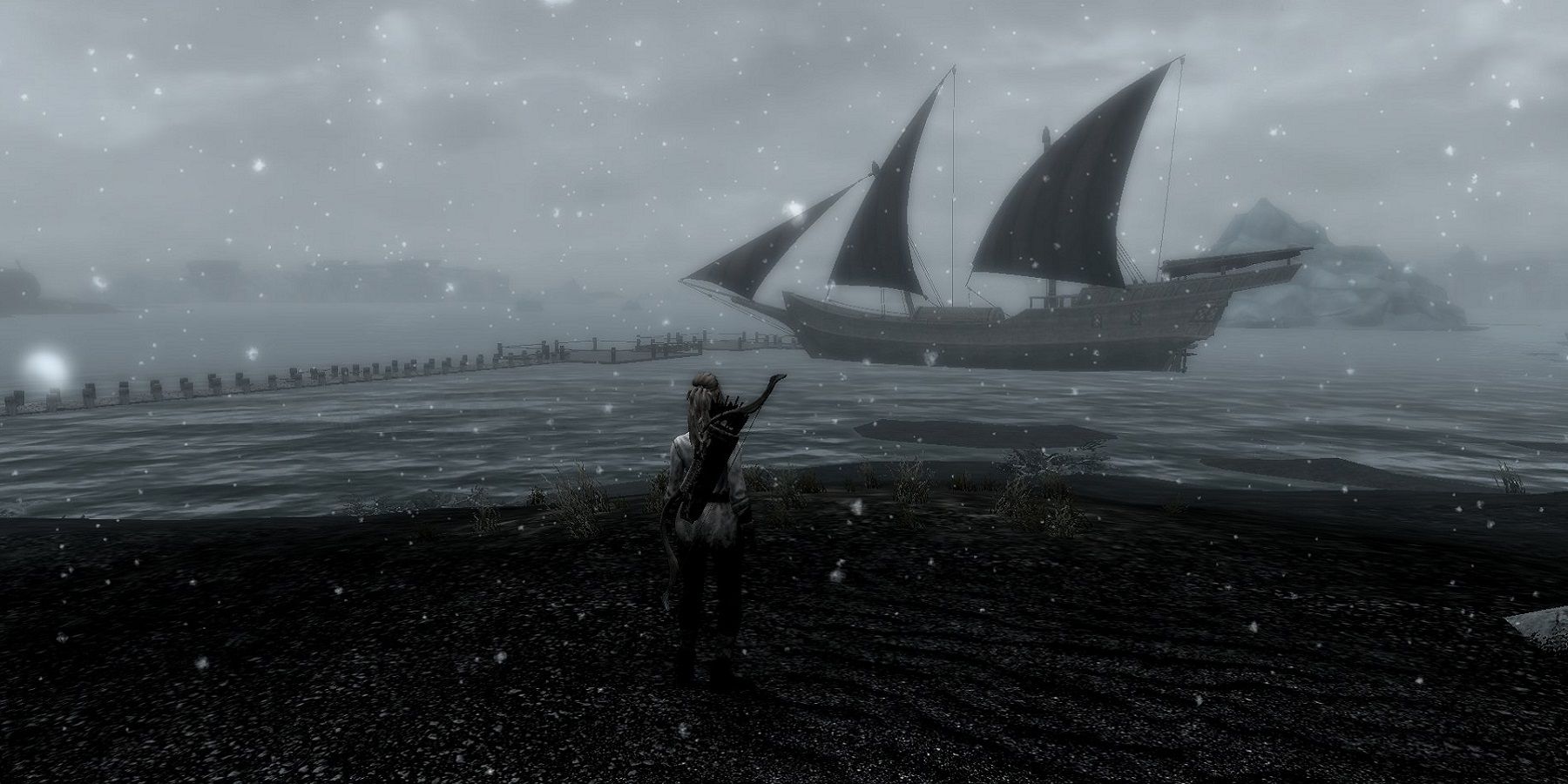 Image from Skyrim showing a character stood on a cold island, with a ship sailing by the distance.