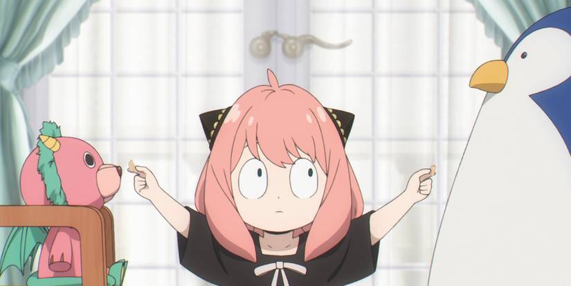 Anya is playing with her toys, a bear/dragon and penguin stuffed animal.