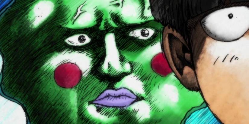 A stern green face with rosy cheeks frowning behind a young man