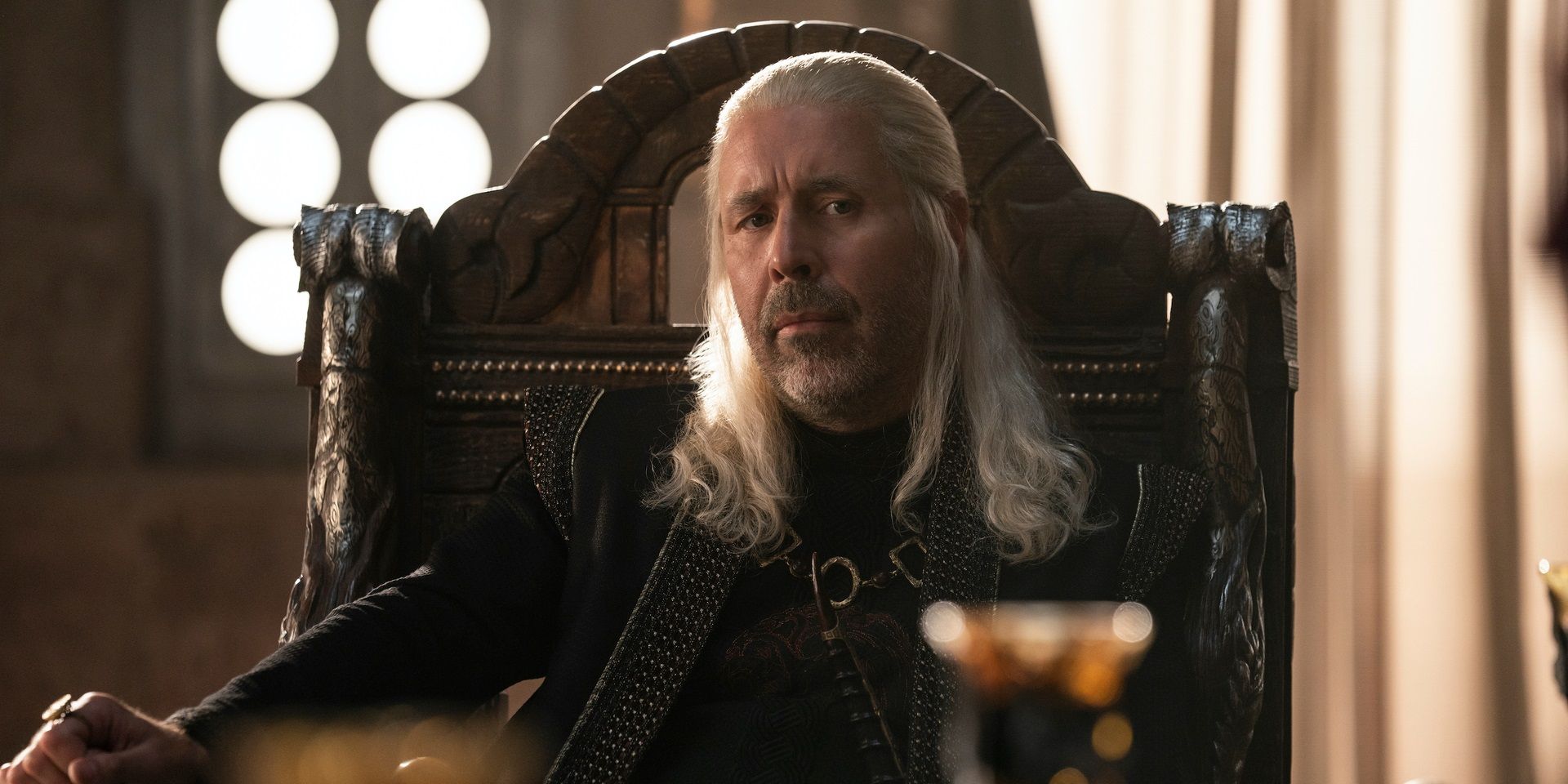 King Viserys Targaryen sitting at the head of a table in House of the Dragon.