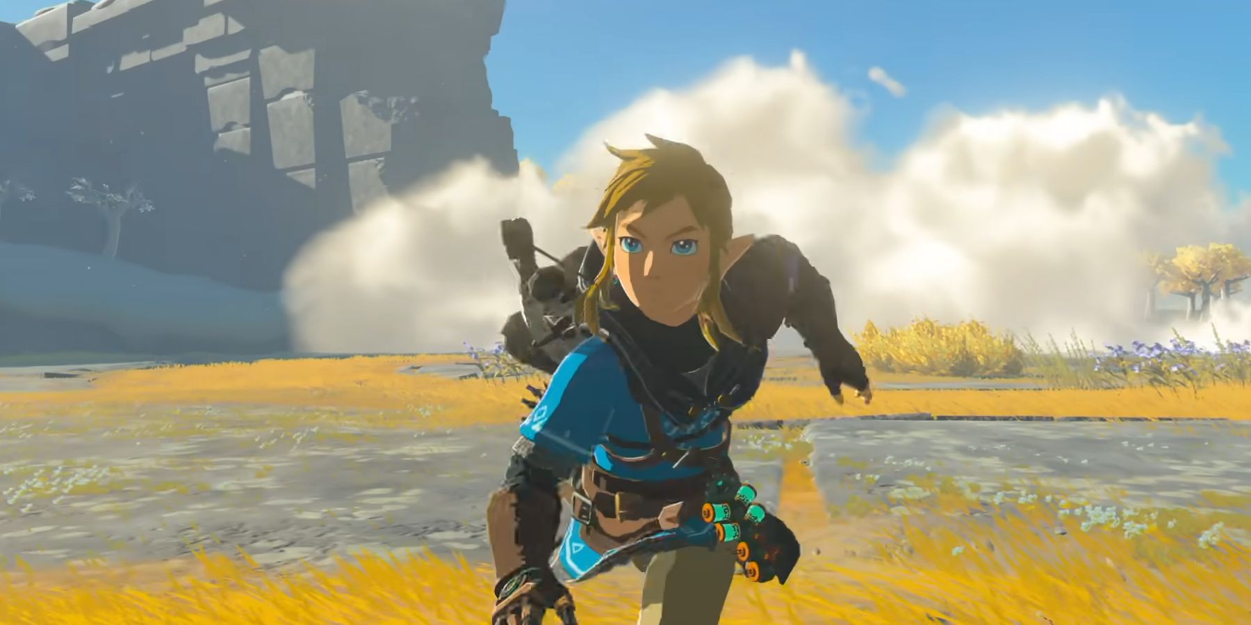 Link (center) running in his blue tunic, with weapons on hs back, and a multi-canstered device on his hip. Image source: Nintendo