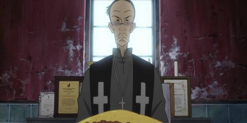 A man with Christian priest attire sitting in front of a window