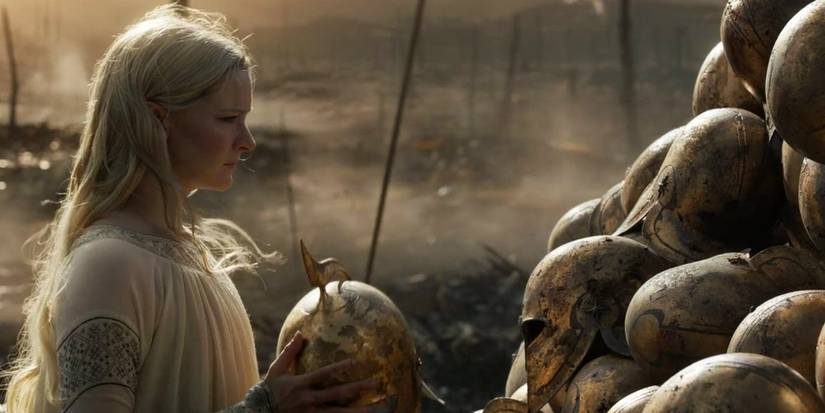 Galadriel stacks the helmets of fallen elven soldiers