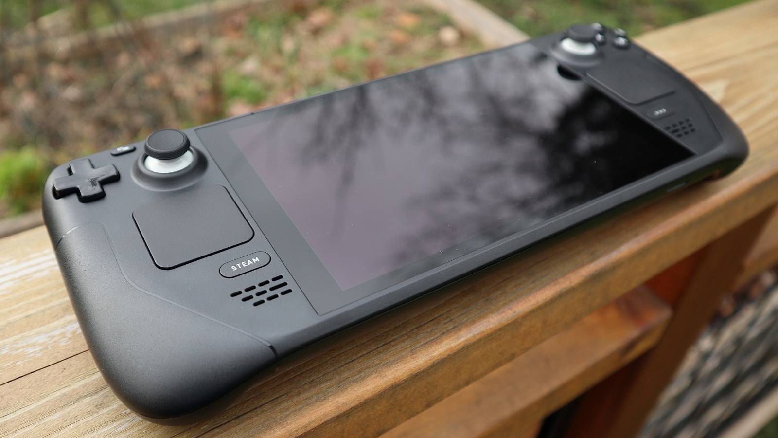 Daytime photo of a Steam Deck on a wooden surface.