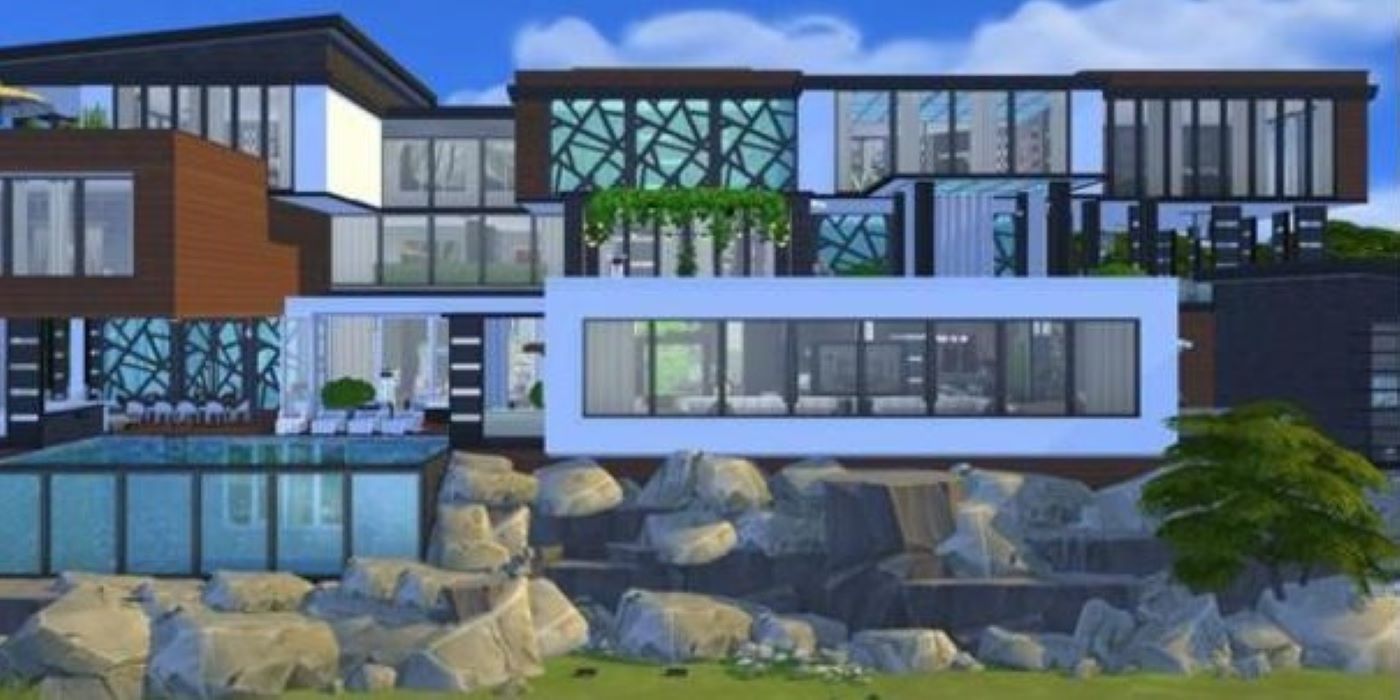 A modern house wit lots of windows surrounded by garden rocks in The Sims 4.