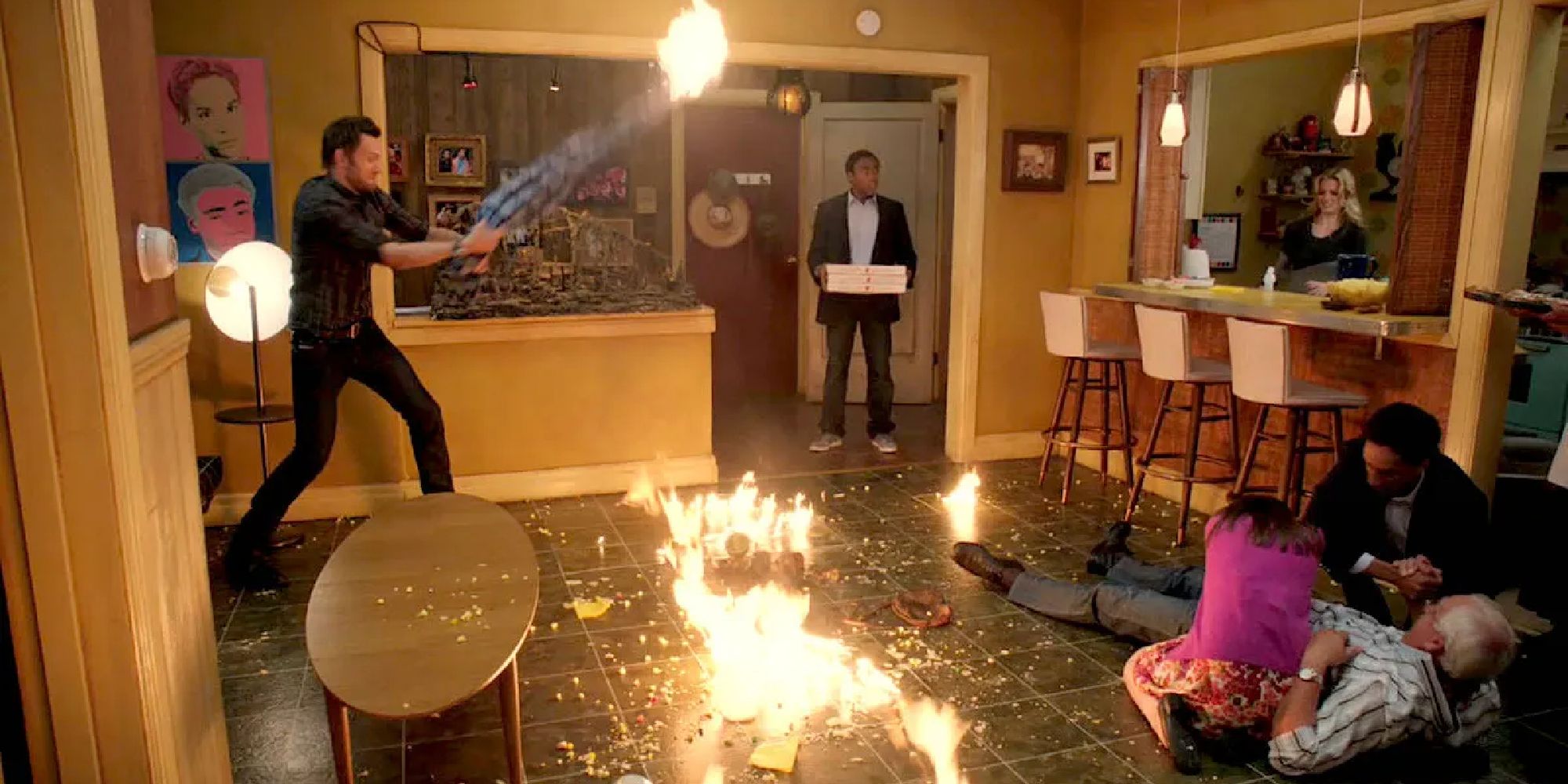 Jeff swinging a flaming blanket, Troy with pizza, Britta throwing water, and Annie and Abed treating an injured Pierce