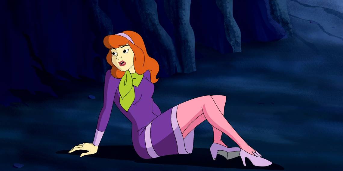 Daphne Blake from Scooby-Doo sitting on the floor of a dark cave.