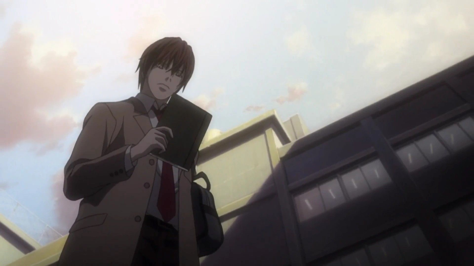 Light Yagami holds the Death Note in his hands