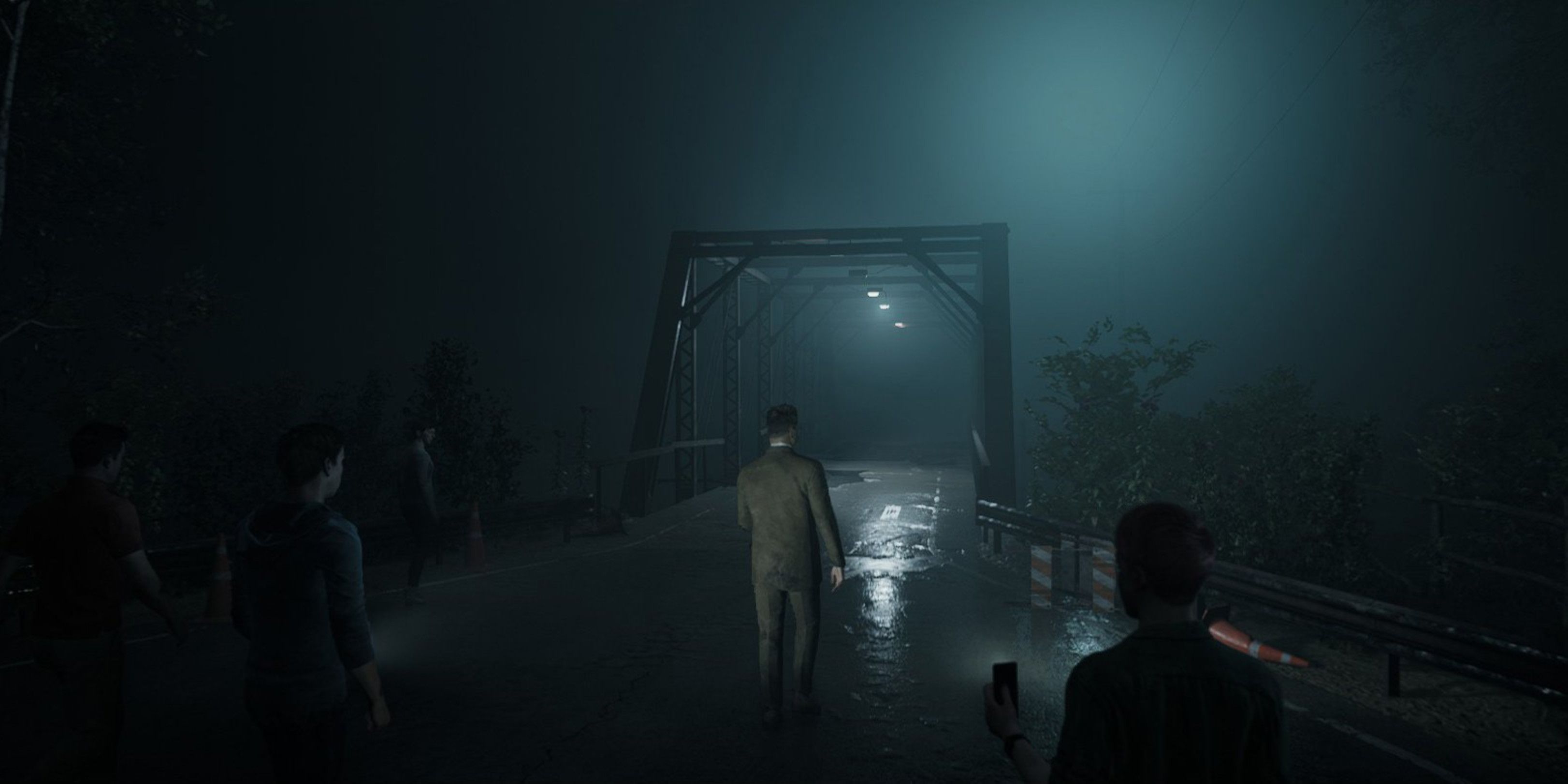 Cast of Little Hope coming across a bridge during a dark and foggy night on their way into Little Hope.