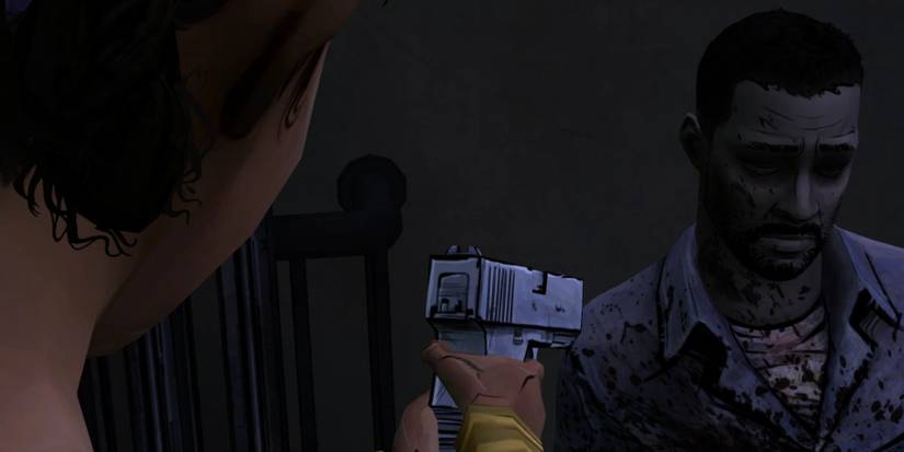 Clementine aims a gun at Lee in The Walking Dead