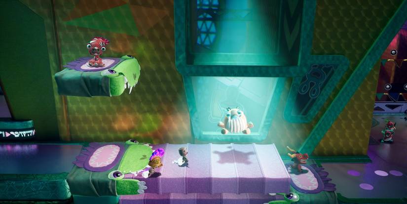 A spotlight shining down on a stage with four Sackboys and another stuffed individual in Sackboy: A Big Adventure