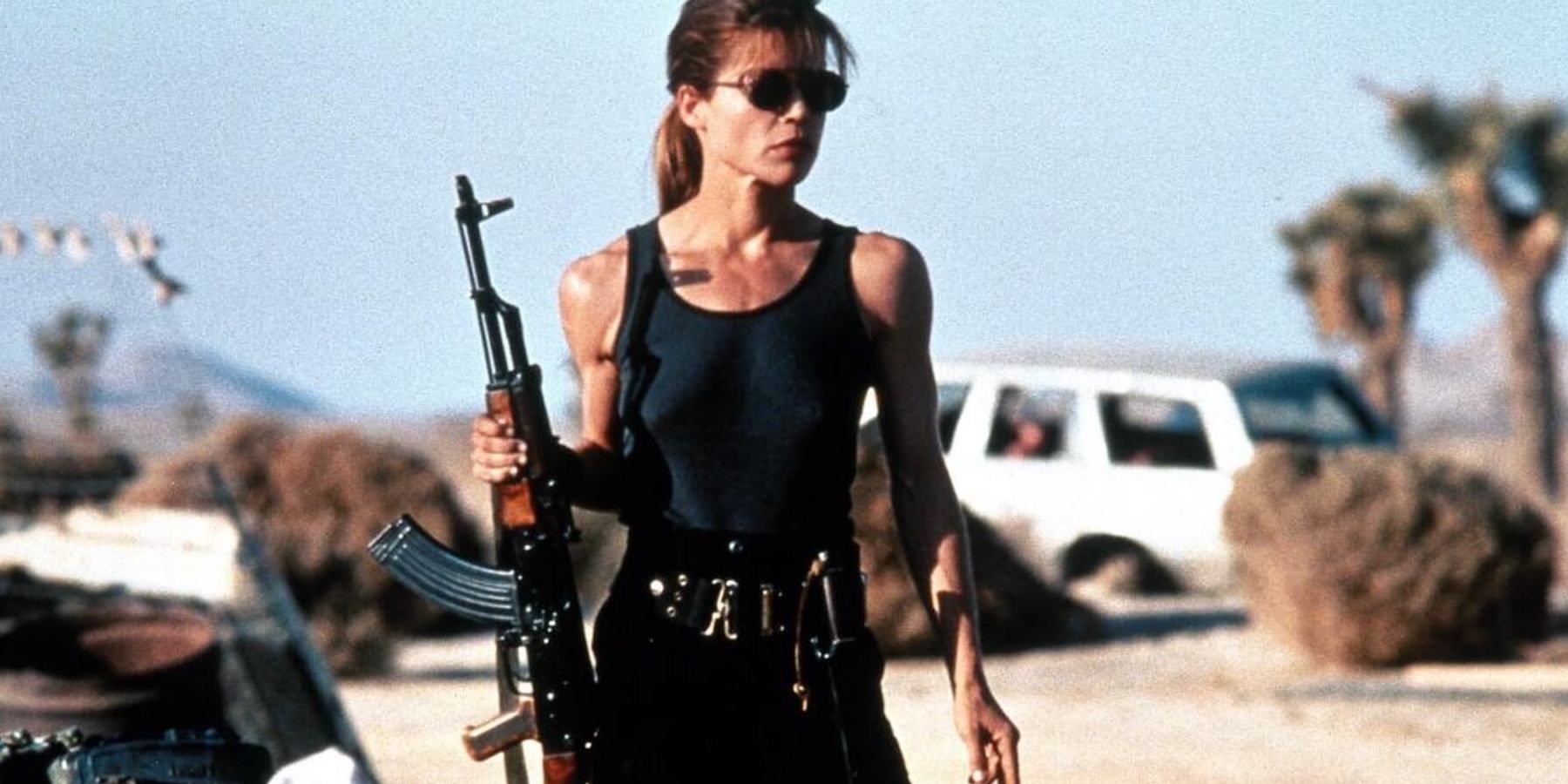Сара Коннор держит пистолет в пустыне.