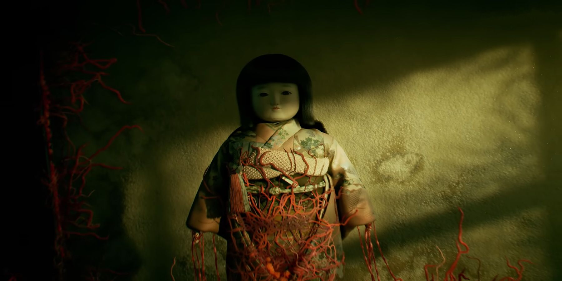 Silent Hill f's Geisha doll being overrun by creeping plant-like vines.