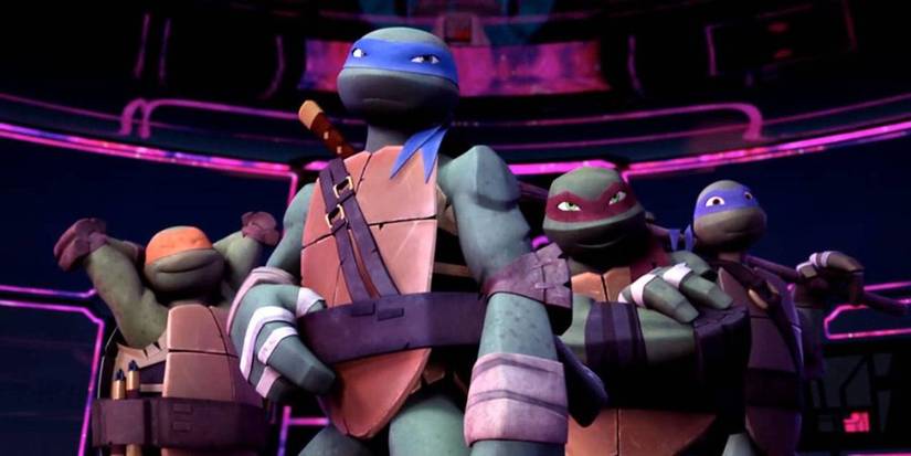The 4 teenage Mutant Ninja Turtles posing in a dark room