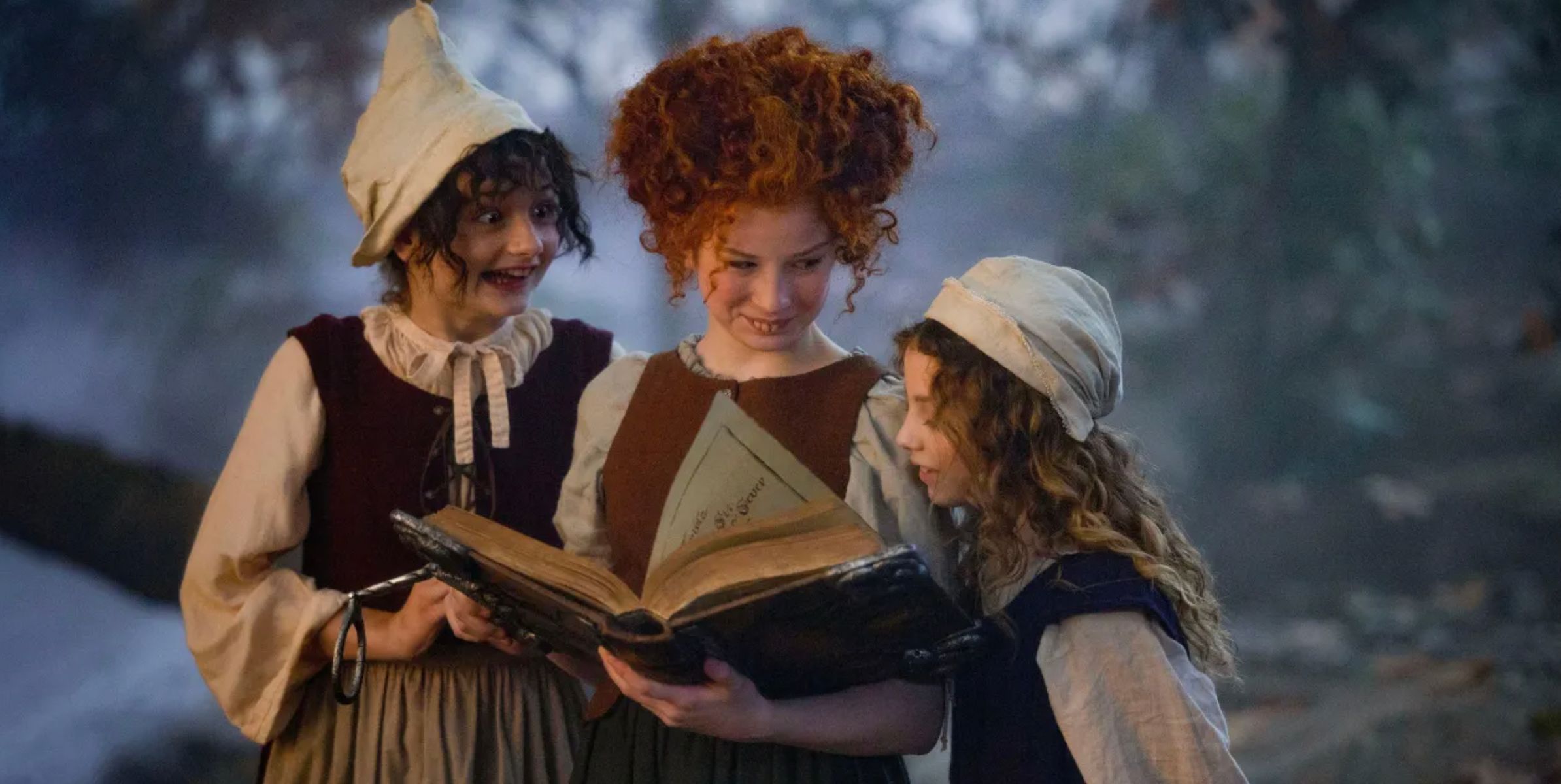 The young Sanderson sisters look through the spellbook in Hocus Pocus 2