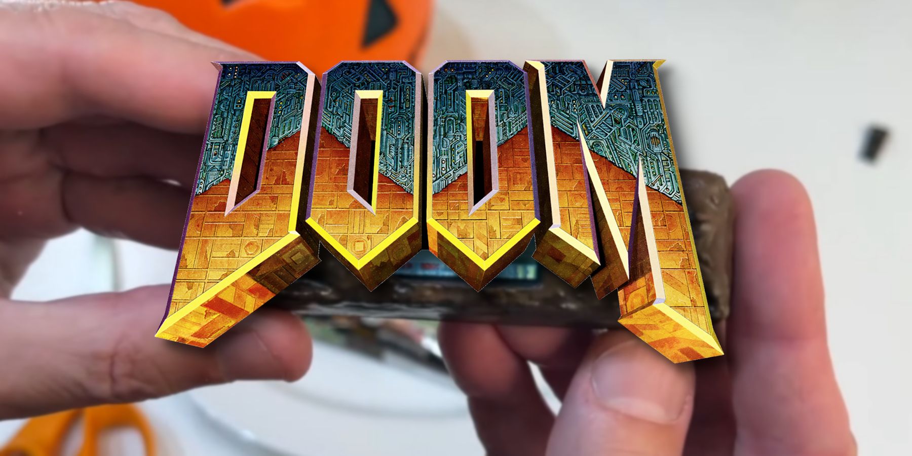 The Doom logo with a hand holding a fake chocolate bar behind it.